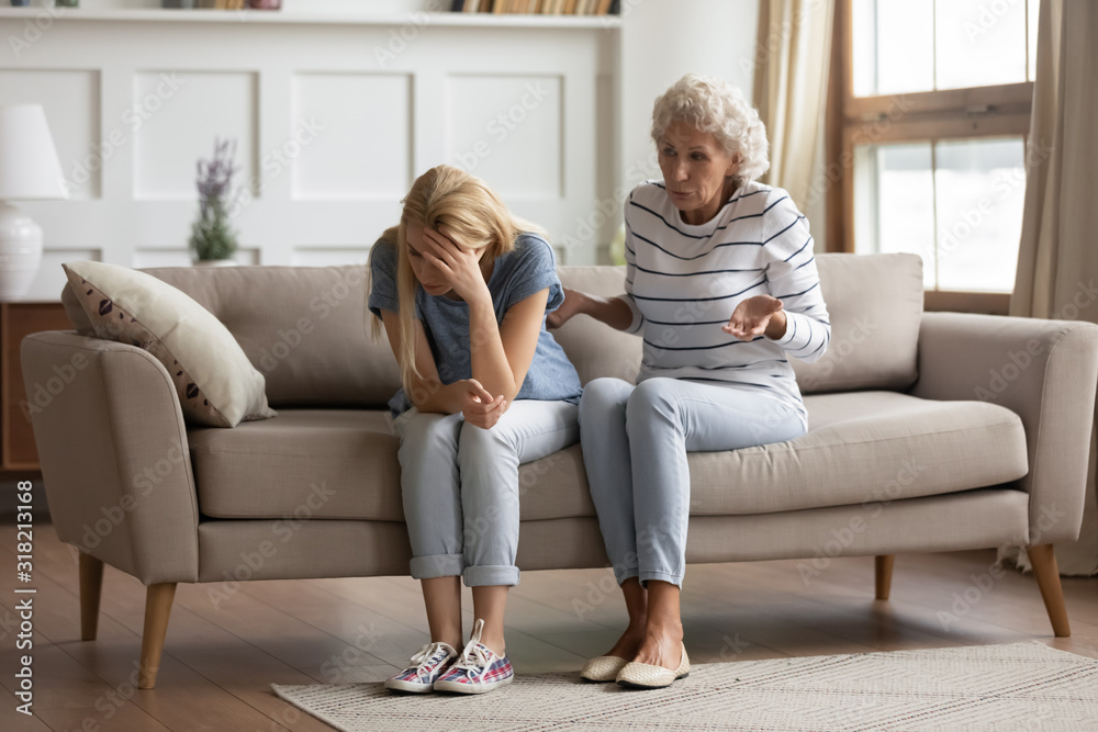 Stressed millennial blonde woman ignoring angry senior old mother. Stressed millennial blonde woman ignoring angry senior old mother.