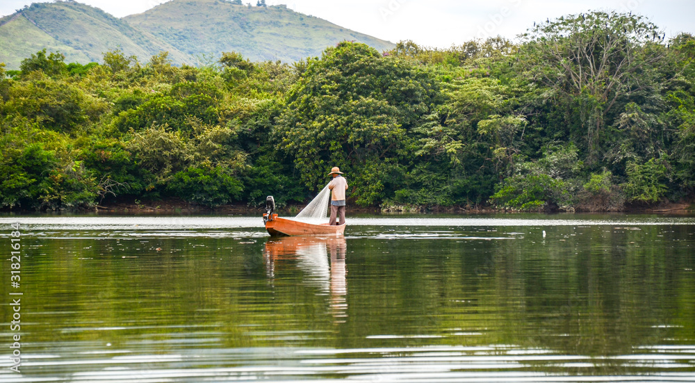 man fishing with a net on a boat