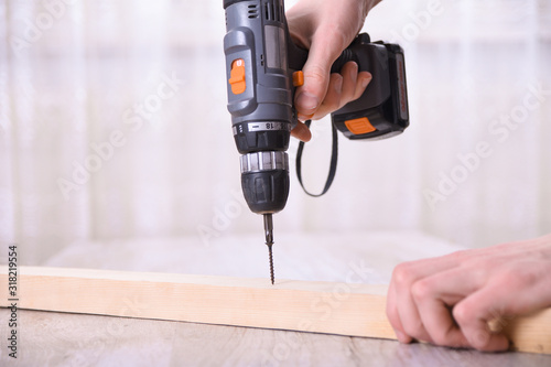 Wallpaper Mural Man is working with furniture assembly using electric screwdriver in new house installation - technician onsite work using hand tools concept Torontodigital.ca