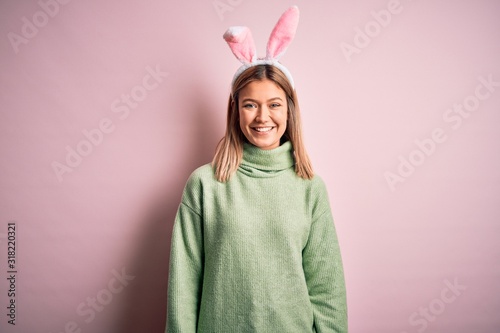 Photography Young beautiful woman wearing easter rabbit ears standing over isolated pink background with a happy and cool smile on face
