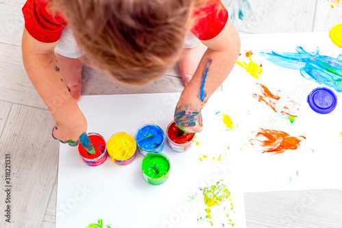 Baby drawing  multi-colored finger paints. Baby hands. Flat lay. Artwork