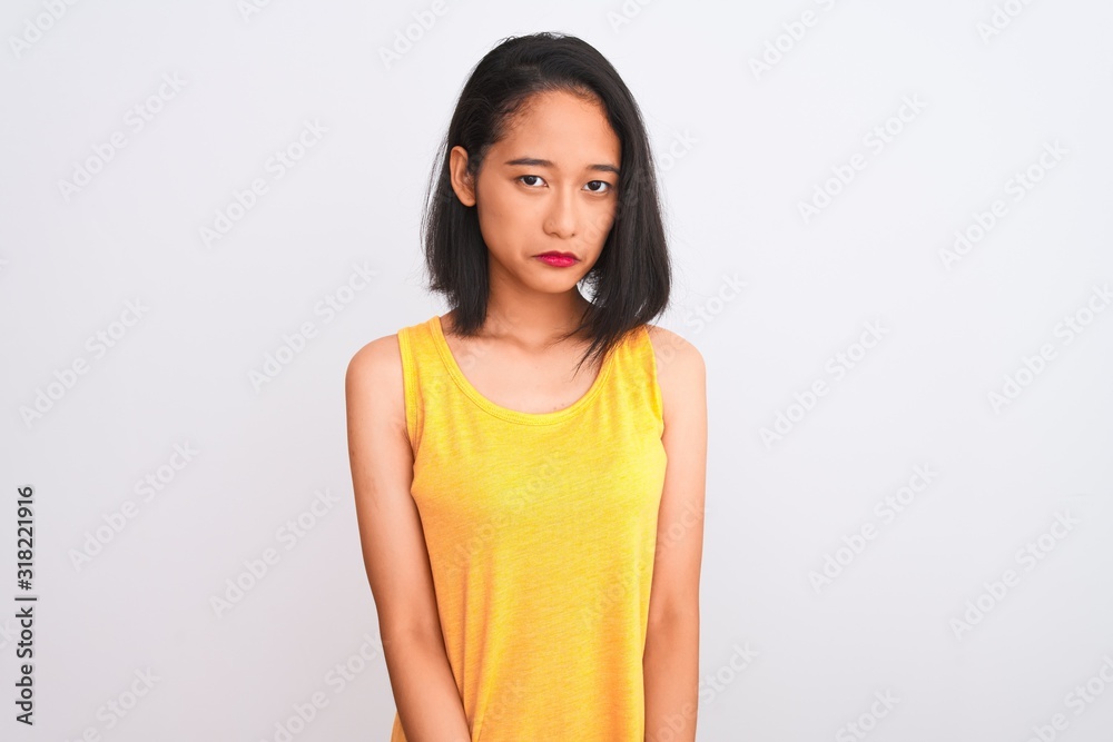 Young chinese woman wearing yellow casual t-shirt standing over isolated white background depressed and worry for distress, crying angry and afraid. Sad expression. Young chinese woman wearing yellow casual t-shirt standing over isolated white background depressed and worry for distress, crying angry and afraid. Sad expression.