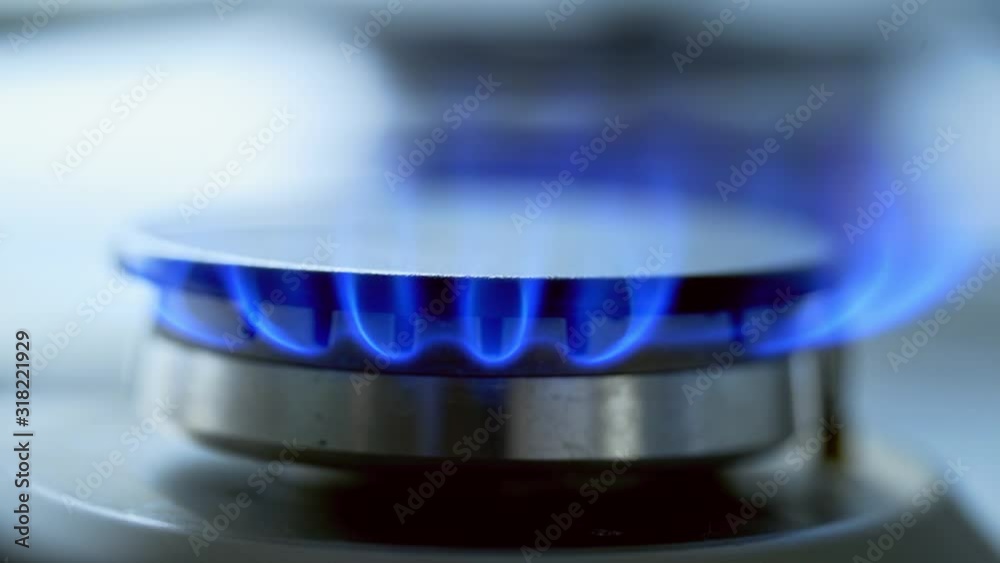 Kitchen burner turning off. Blue flame on a stove side burner. Natural gas stops burning. Close