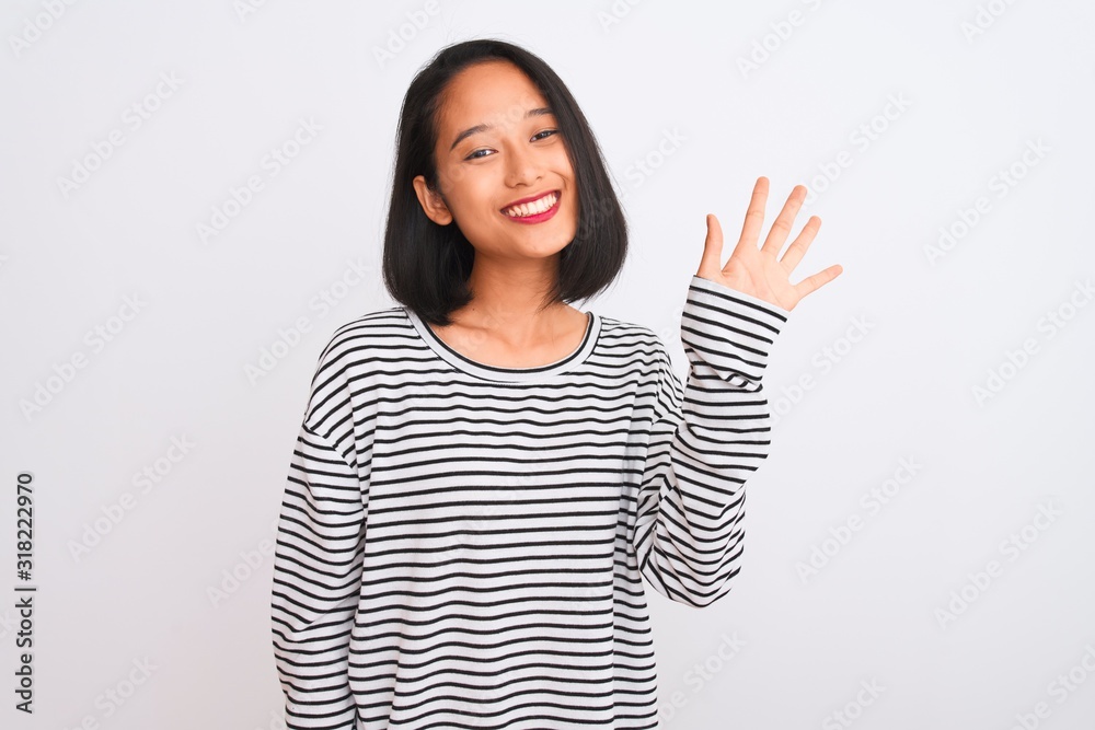 Young chinese woman wearing striped t-shirt standing over isolated white background showing and pointing up with fingers number five while smiling confident and happy. Young chinese woman wearing striped t-shirt standing over isolated white background showing and pointing up with fingers number five while smiling confident and happy.