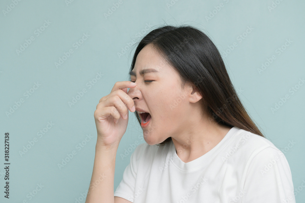 asian young Women Sneezing on light blue background. asian young Women Sneezing on light blue background.