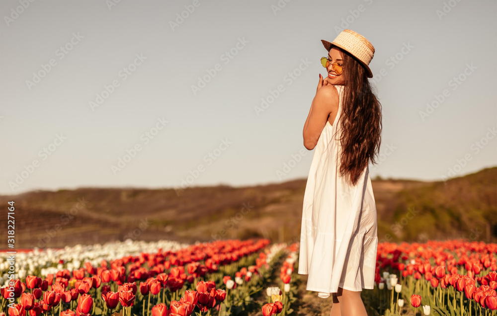Optimistic lady enjoying summer day in tulip field