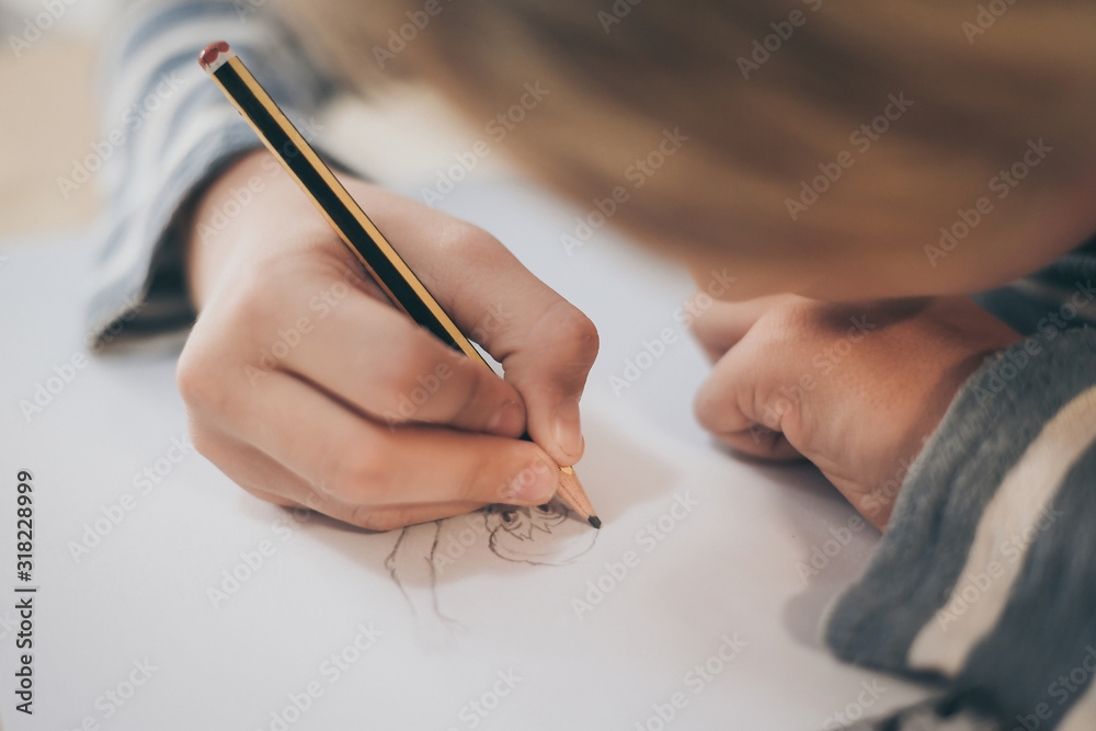 Close up view of student drawing with pencil. Boy doing homework writing on a paper. Kid hold a pencil and draw a manga at home. Teen drawing sitting at the table. Education art talent ability concept Close up view of student drawing with pencil. Boy doing homework writing on a paper. Kid hold a pencil and draw a manga at home. Teen drawing sitting at the table. Education art talent ability concept