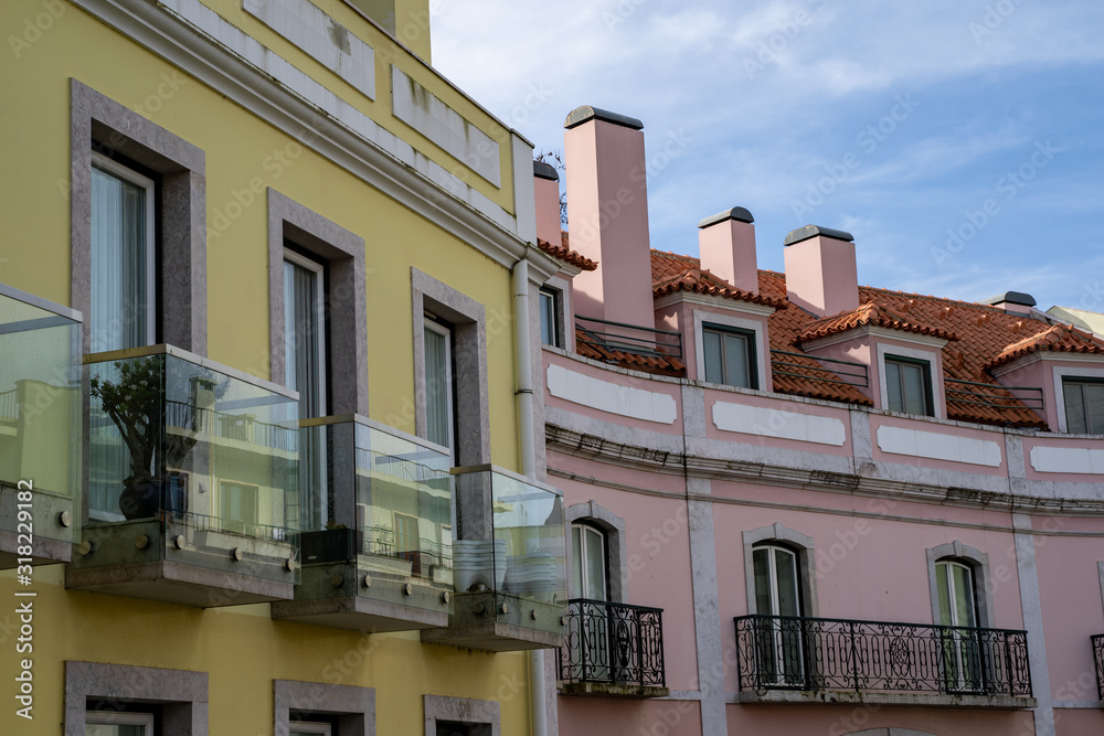 Typical building facades in Alfama district of Lisbon, Portugal, with bright colors, windows and balconies