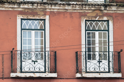 Windows with decorative balconies, traditional architecturial style in downtown Lisbon Portugal. Orange wall