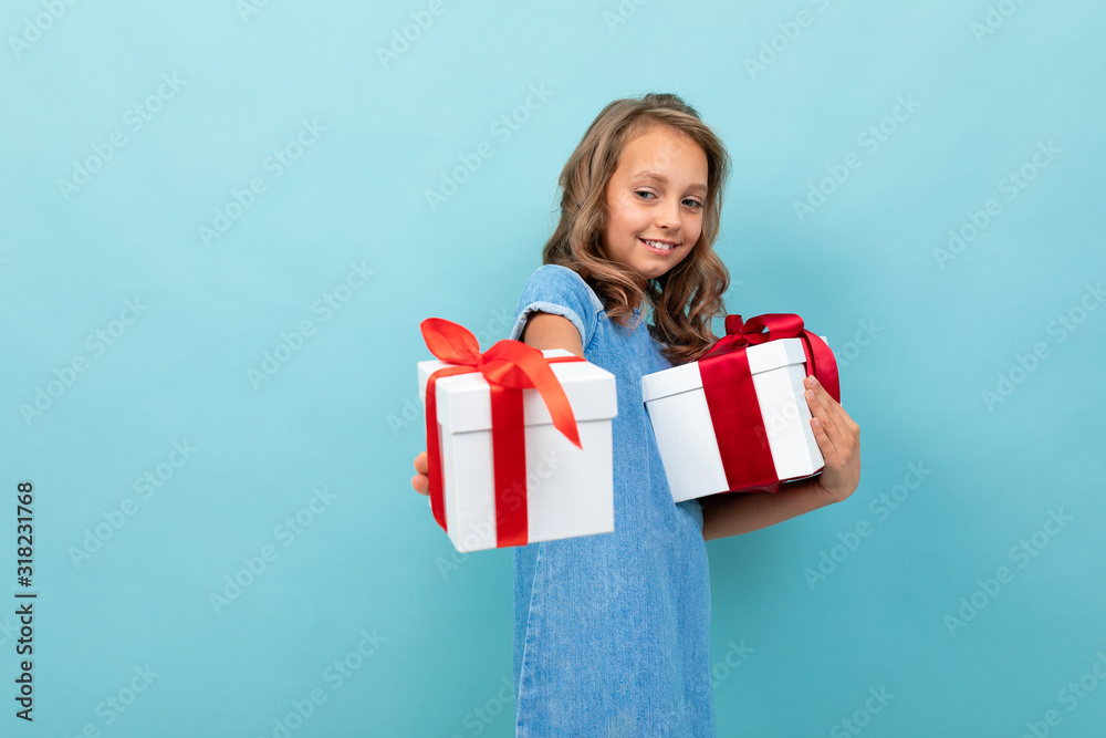 Caucasian girl with wavy brown hair in blue dress, big hat holds a boxes with gifts and rejoices Caucasian girl with wavy brown hair in blue dress, big hat holds a boxes with gifts and rejoices