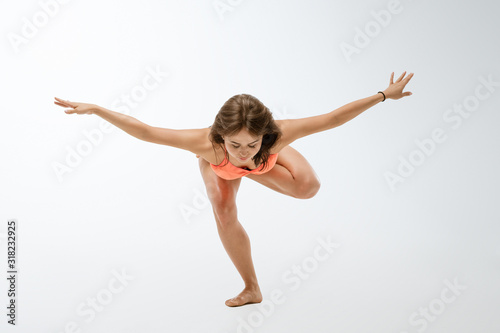 young woman doing yoga on a white background