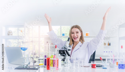 pretty scientist work reserching and cheerfully in a chemical laboratory