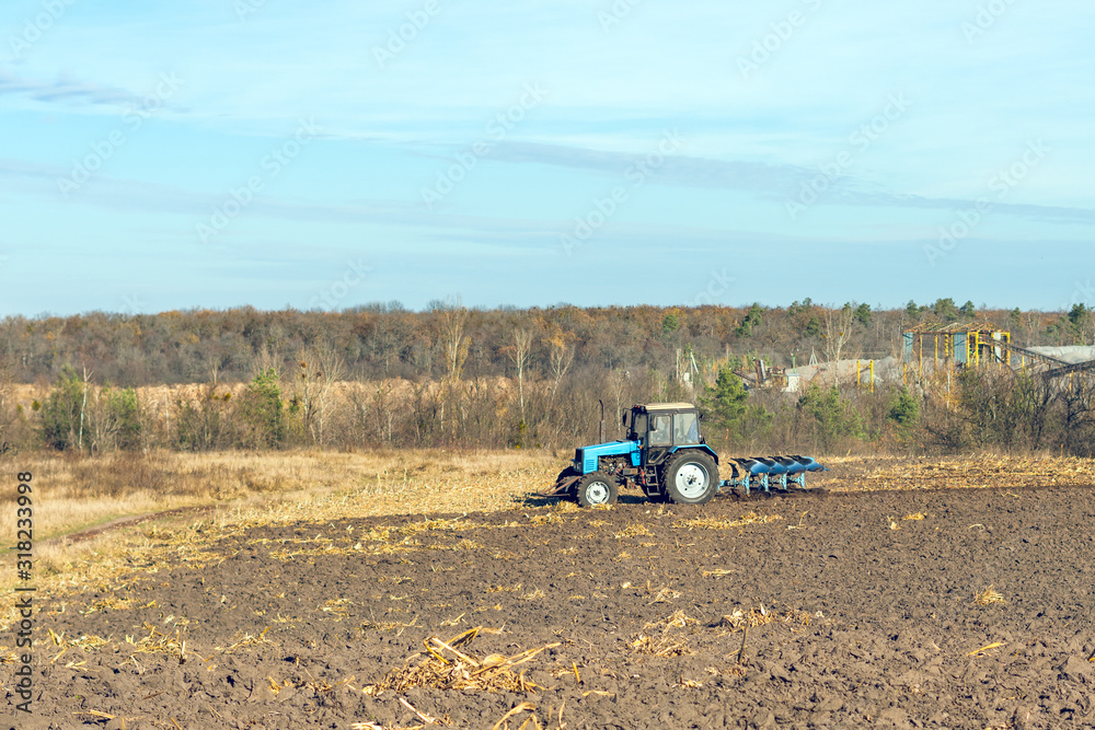Obraz premium The tractor plows a field, cultivates the soil for sowing grain