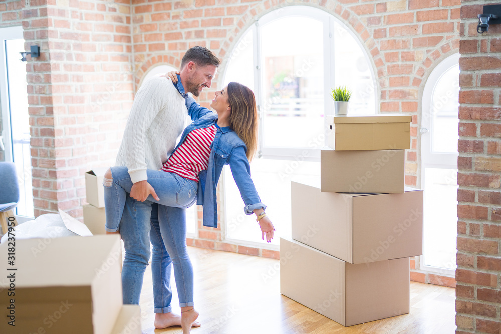 Young beautiful couple dancing at new home around cardboard boxes Young beautiful couple dancing at new home around cardboard boxes