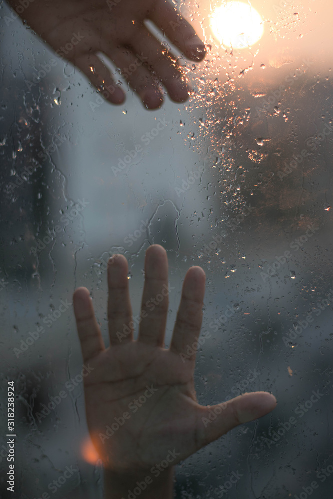Two hands is trying to reach each other on a raindrop window Stock ...
