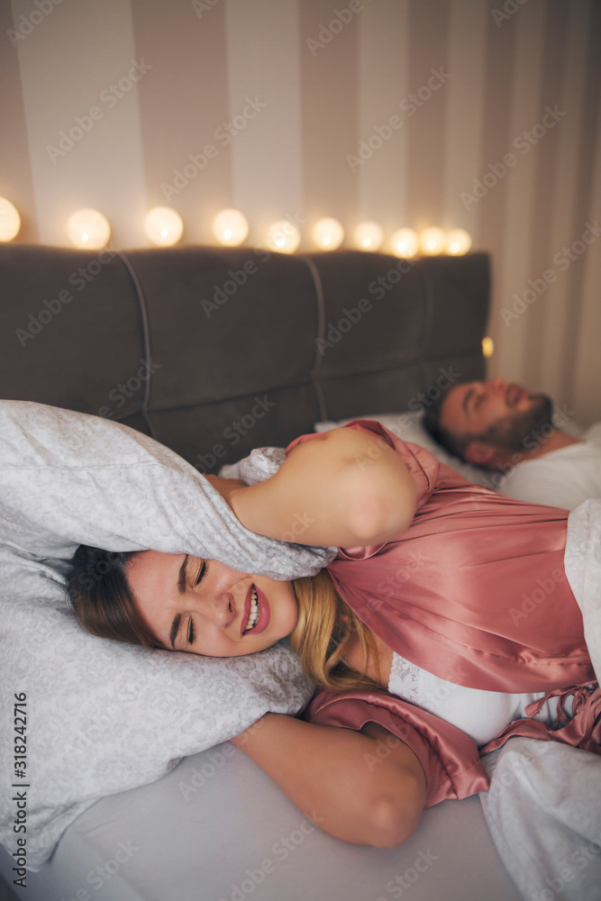 Couple lies in bed while man snores. Couple lies in bed while man snores.