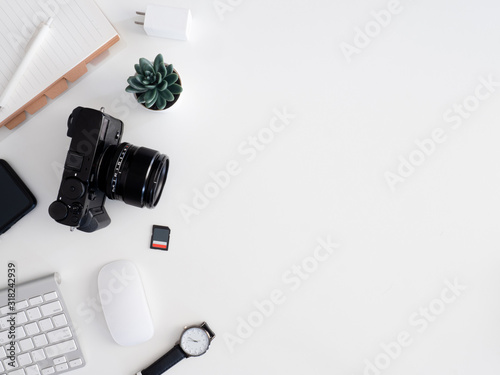 Fototapeta Naklejka Na Ścianę i Meble -  top view of photographer work station, work space concept with digital camera, memory card, keyboard and smartphone on white table background