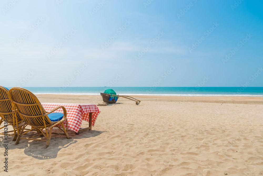 Obraz premium Beautiful beach view with fishing boat, yellow sand and blue ocean, Goa state in India