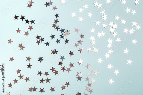 Star shaped silver sequins over blue background.