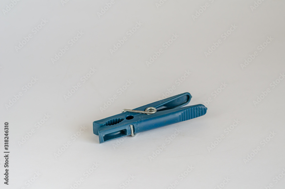 Naklejka premium Blue plastic clothespin. Image of a single clothespin on a light background. Eye level shooting. Selective focus.