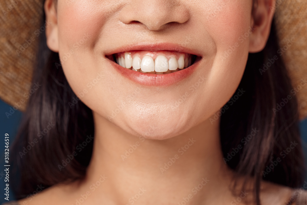 Freestyle. Young woman in hat standing isolated on dark blue smiling toothy close-up Freestyle. Young woman in hat standing isolated on dark blue smiling toothy close-up