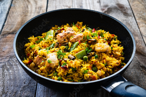 Paella seafood in cooking pan on wooden background