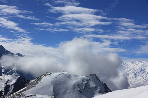 Snowy mountains against the blue sky with white clouds. Mountains of Nepal