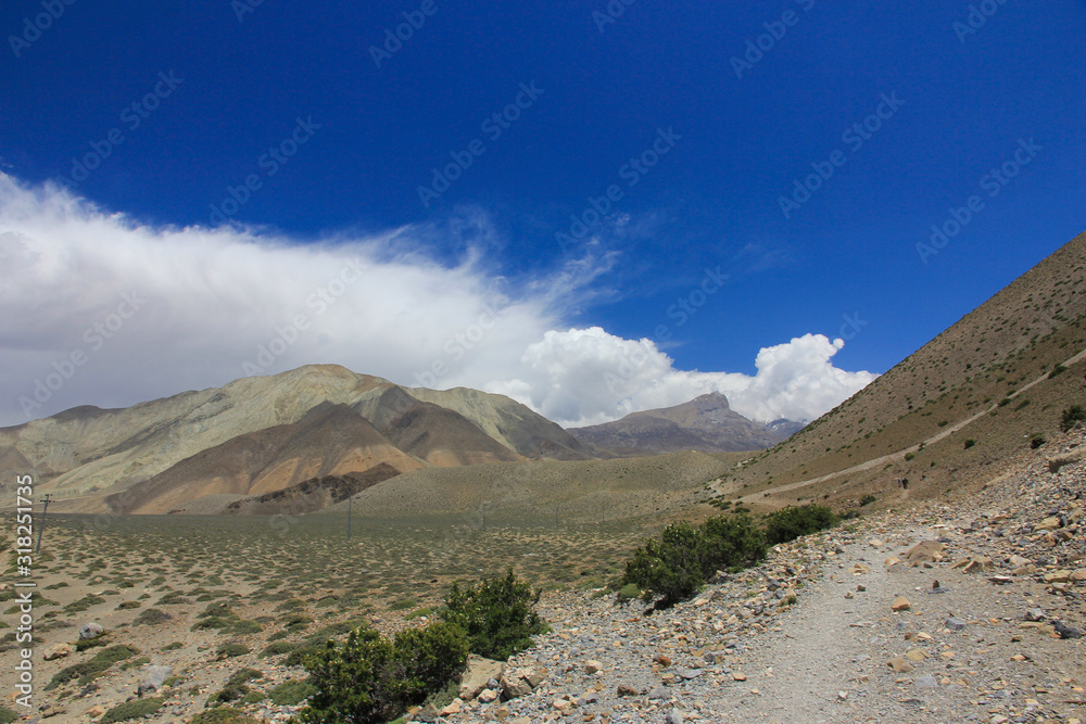 Fototapeta premium Brown mountains against the blue sky with white clouds