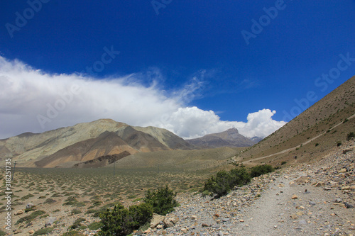 Brown mountains against the blue sky with white clouds