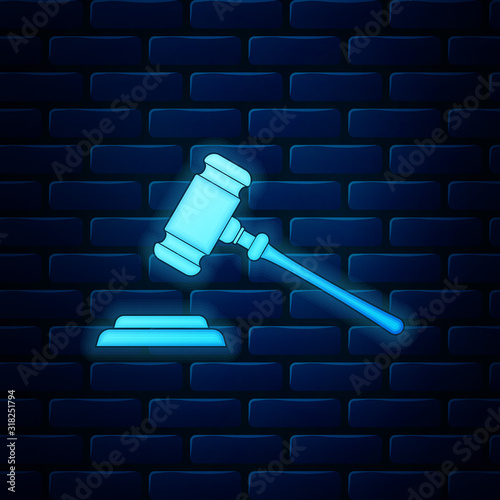 Glowing neon Judge gavel icon isolated on brick wall background. Gavel for adjudication of sentences and bills, court, justice, with a stand. Auction hammer symbol. Vector Illustration