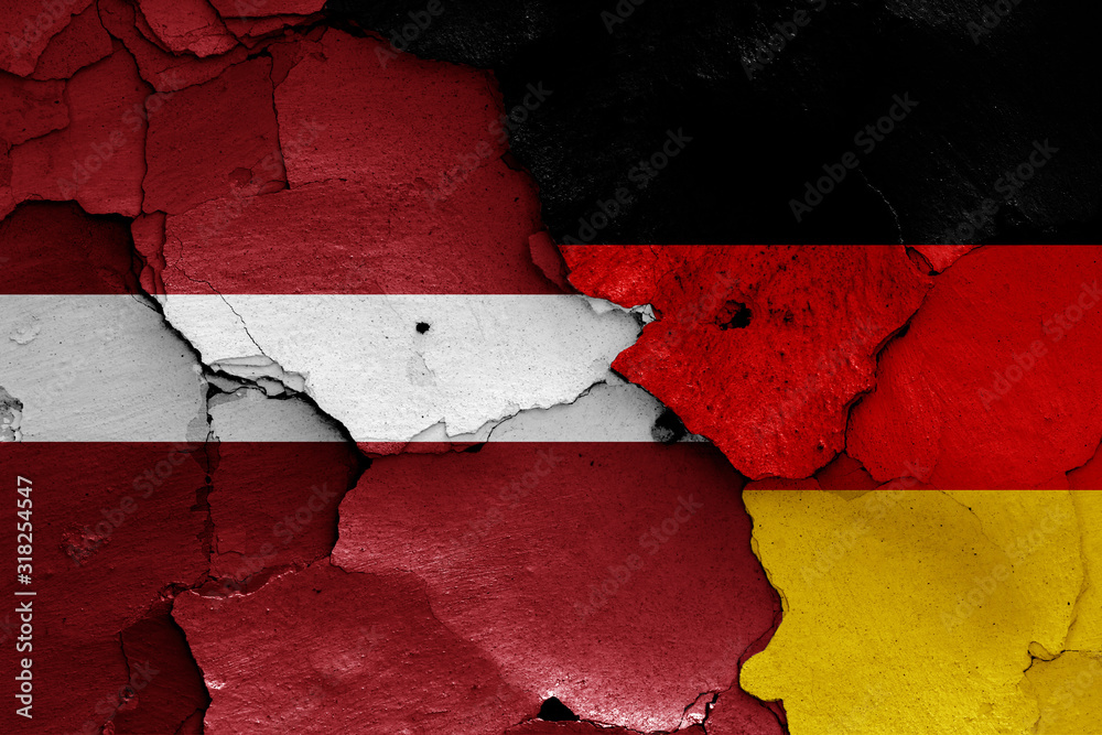 flags of Latvia and Germany painted on cracked wall