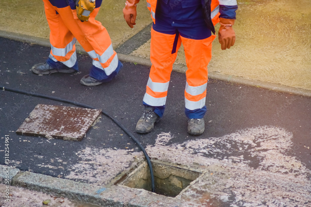workers cleaning and maintaining the sewers on the roads workers cleaning and maintaining the sewers on the roads