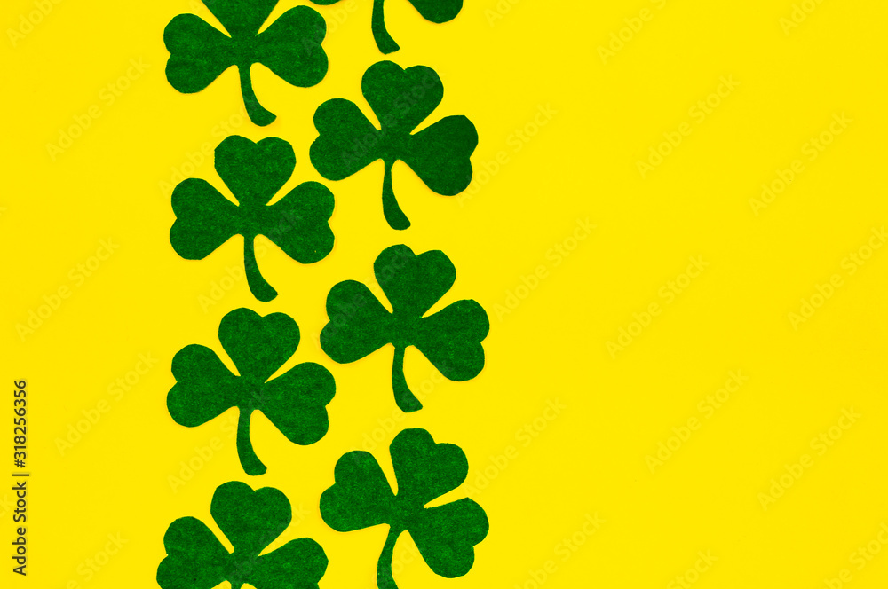 Happy Saint Patrick's of handmade paper clover leaves on yellow background with copy space Happy Saint Patrick's of handmade paper clover leaves on yellow background with copy space