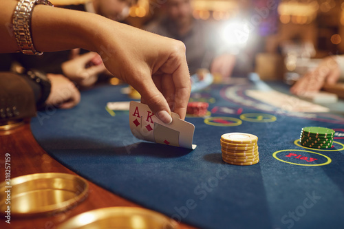 Close-up hands of a poker player checking cards in a casino. photo