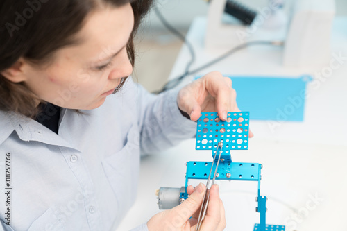 Student woman in robotics laboratory working on project mechatronics