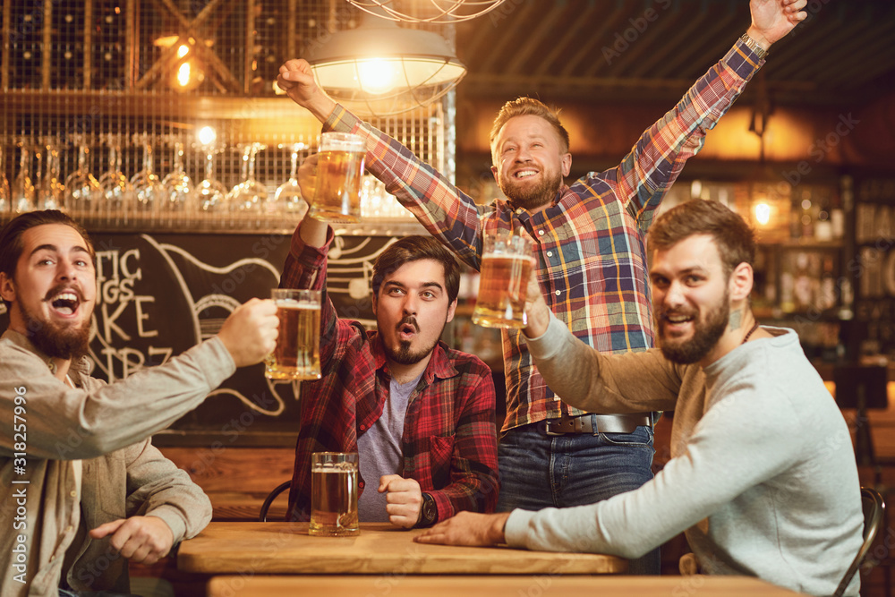 Fototapeta premium A group of guys watching sports on tv in a pub bar.