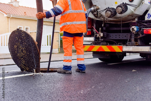 workers cleaning and maintaining the sewers on the roads photo