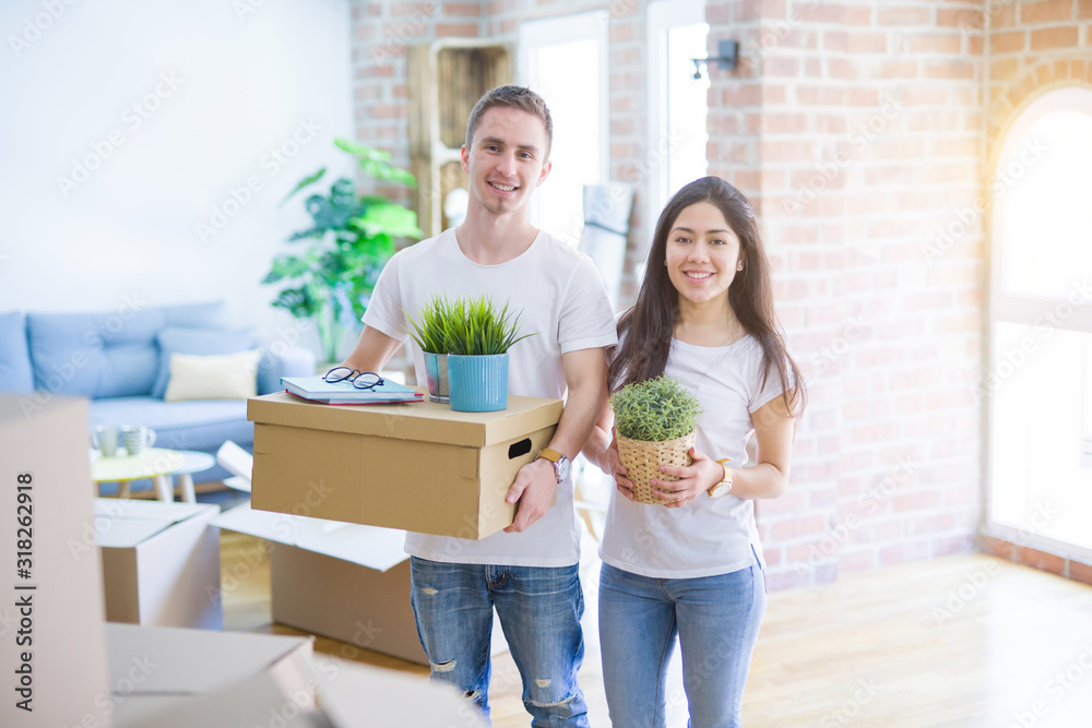 Young beautiful couple moving cardboard boxes at new home Young beautiful couple moving cardboard boxes at new home