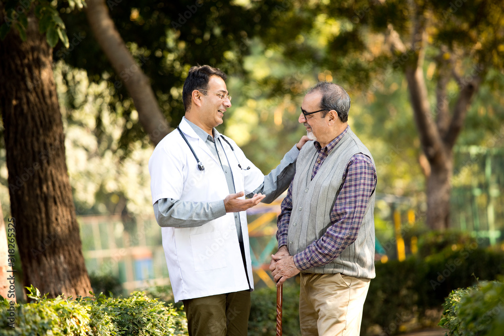 Doctor talking with senior man in hospital garden Doctor talking with senior man in hospital garden