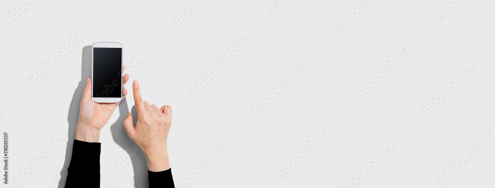 Person using a white smartphone - overhead view - obrazy, fototapety, plakaty 