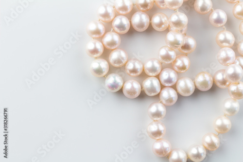 Pink pearl necklace isolated on white background - top view photo of beautiful real pink pearls