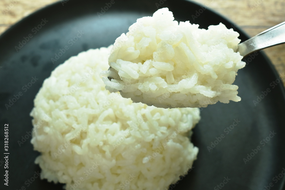 plain rice scooping in silver spoon on plate plain rice scooping in silver spoon on plate