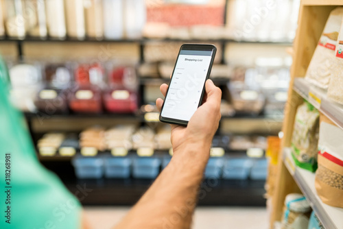 Male Customer Using Mobile Phone In Supermarket