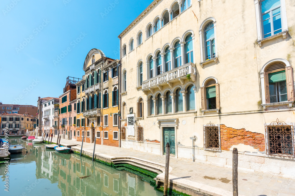Venice. Venetian stone embankments, canals, bridges, parapet, railing and colorful buildings. Palazzo. Architecture details. Authentic venetian canals with boats. Travel tourism vacation in Italy.