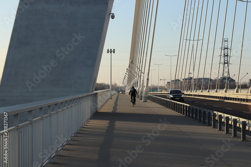 Rzeszow, Poland - 9 9 2018: Suspended road bridge across the Wislok River. Metal construction technological structure. Modern architecture. A white cross on a blue background is a symbol of the city