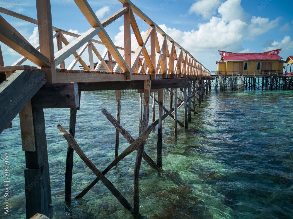 scenery of water chalet above the coral reef during low tide in Semporna island.