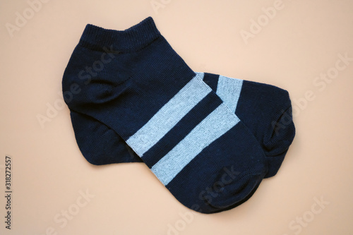 Women's low-rise socks. Dark blue socks with two gray stripes on an orange background top view. A pair of new cotton socks for sports.