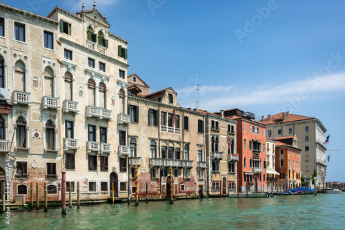Fototapeta Naklejka Na Ścianę i Meble -  Venice, Italy. View of Venice from the Grand Canal. Venetian old colorful buildings against blue sky and white clouds. Boat trip through the canals of Venice. Vacation in Europe concept.