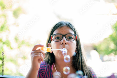 Adolescent girl blowing bubbles on the balcony