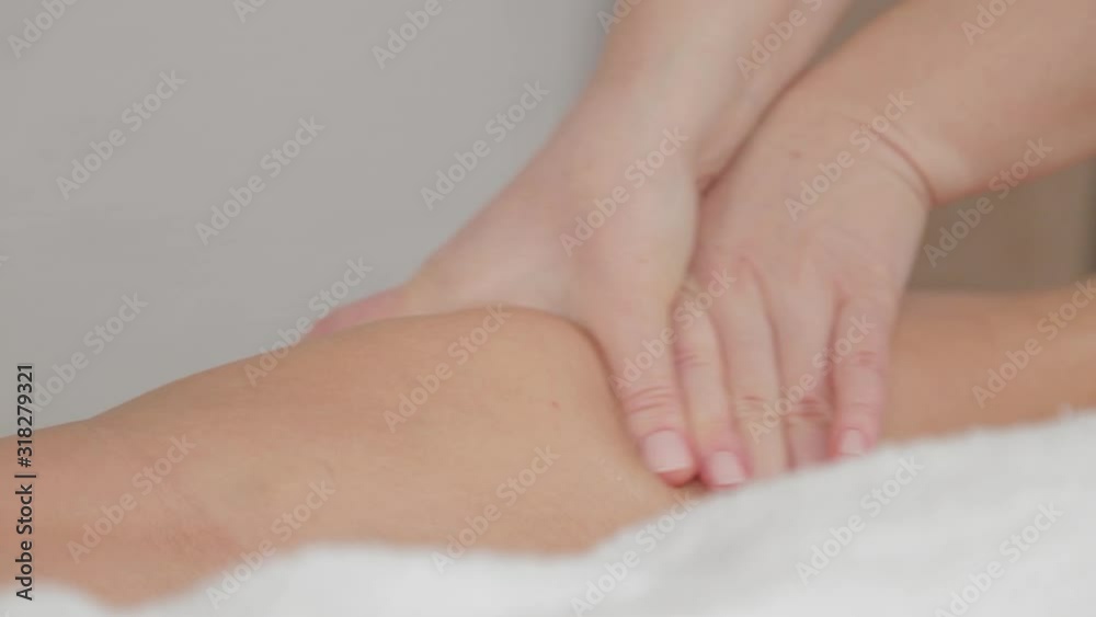 Woman massage therapist does massage on the legs of a young girl. Woman massage therapist does massage on the legs of a young girl.